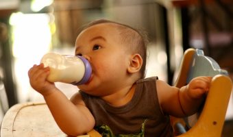 baby in chair drinking milk