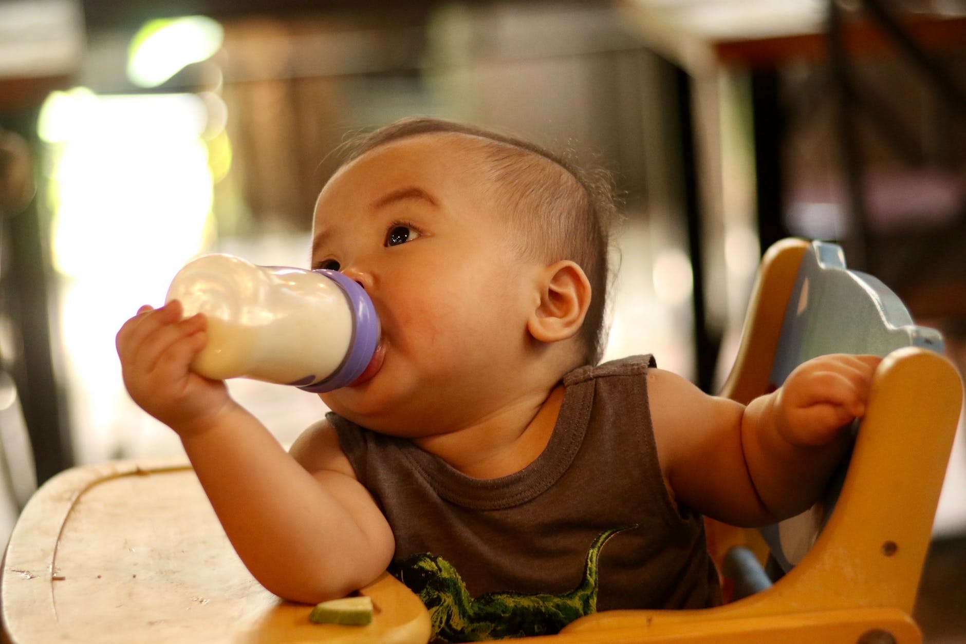 baby in chair drinking milk