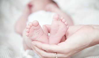close up of hands holding baby feet